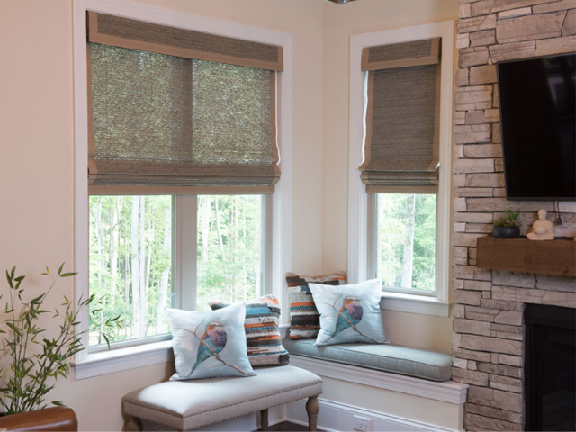 A seating area next to windows that are partially covered by window shades.