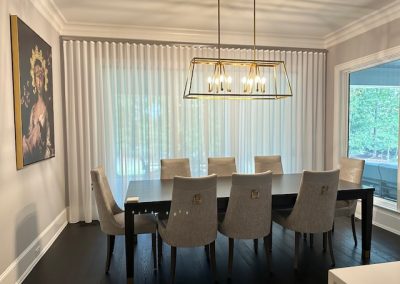 An elegant dining room with custom drapes hanging floor to ceiling.