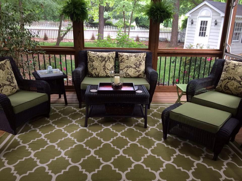 Front porch furniture with stylized custom pillows and coordinating rug
