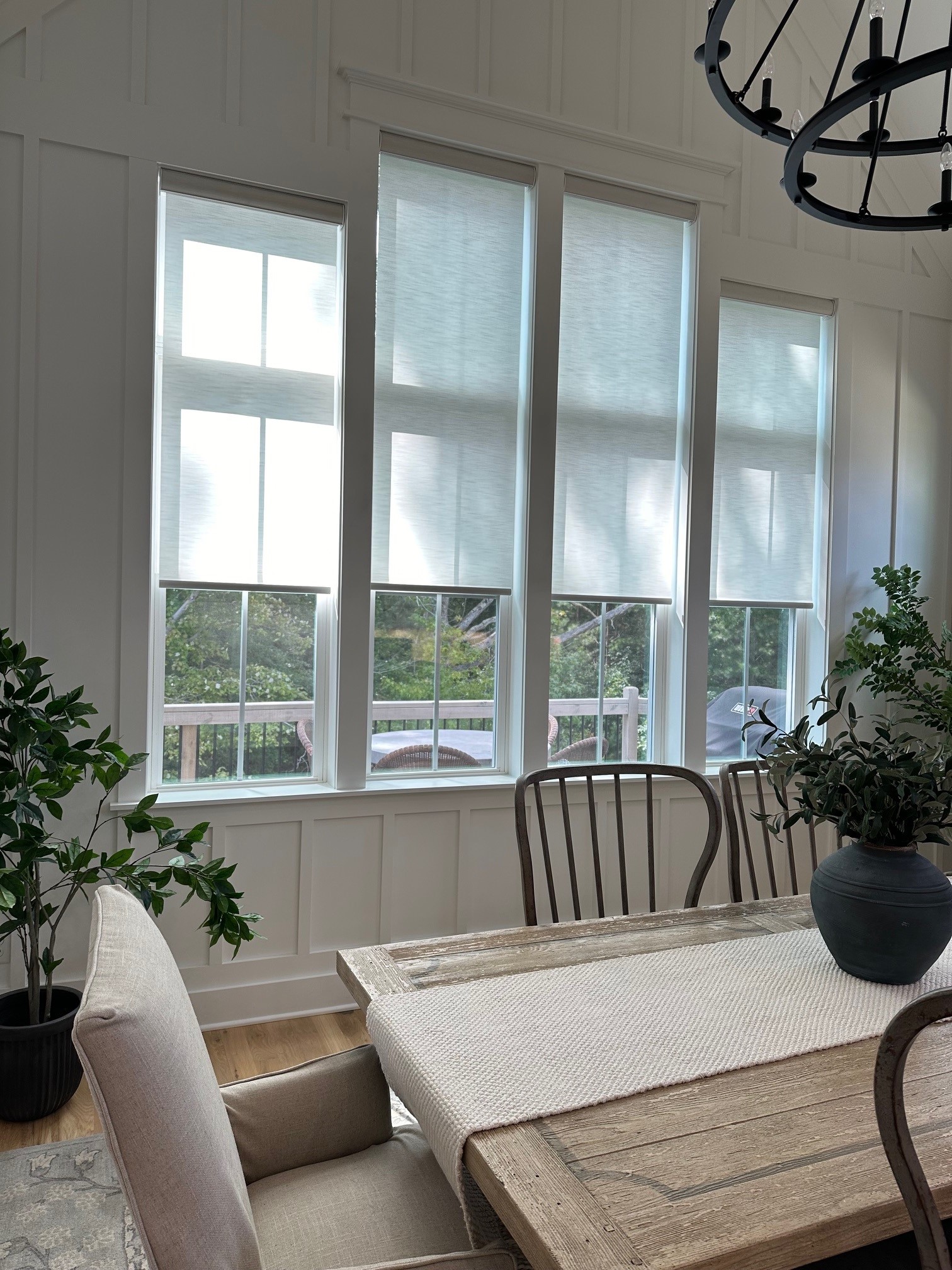 Custom light-filtering roller shades provide privacy and glare control while maintaining a bright, airy kitchen dining space.